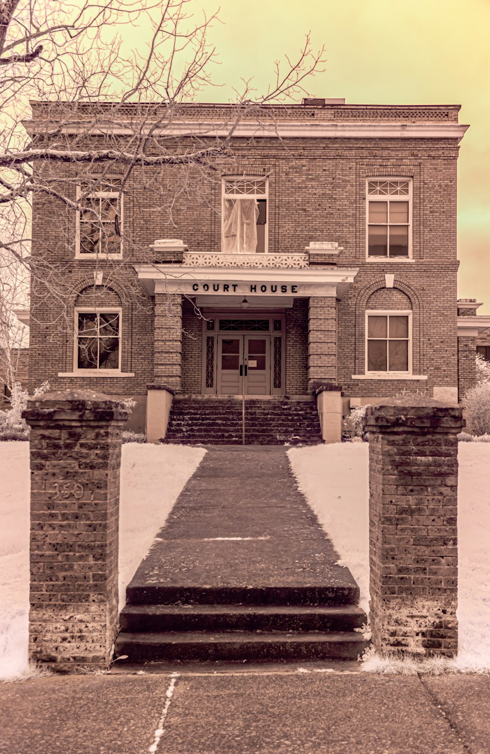 an old brick building with snow on the ground