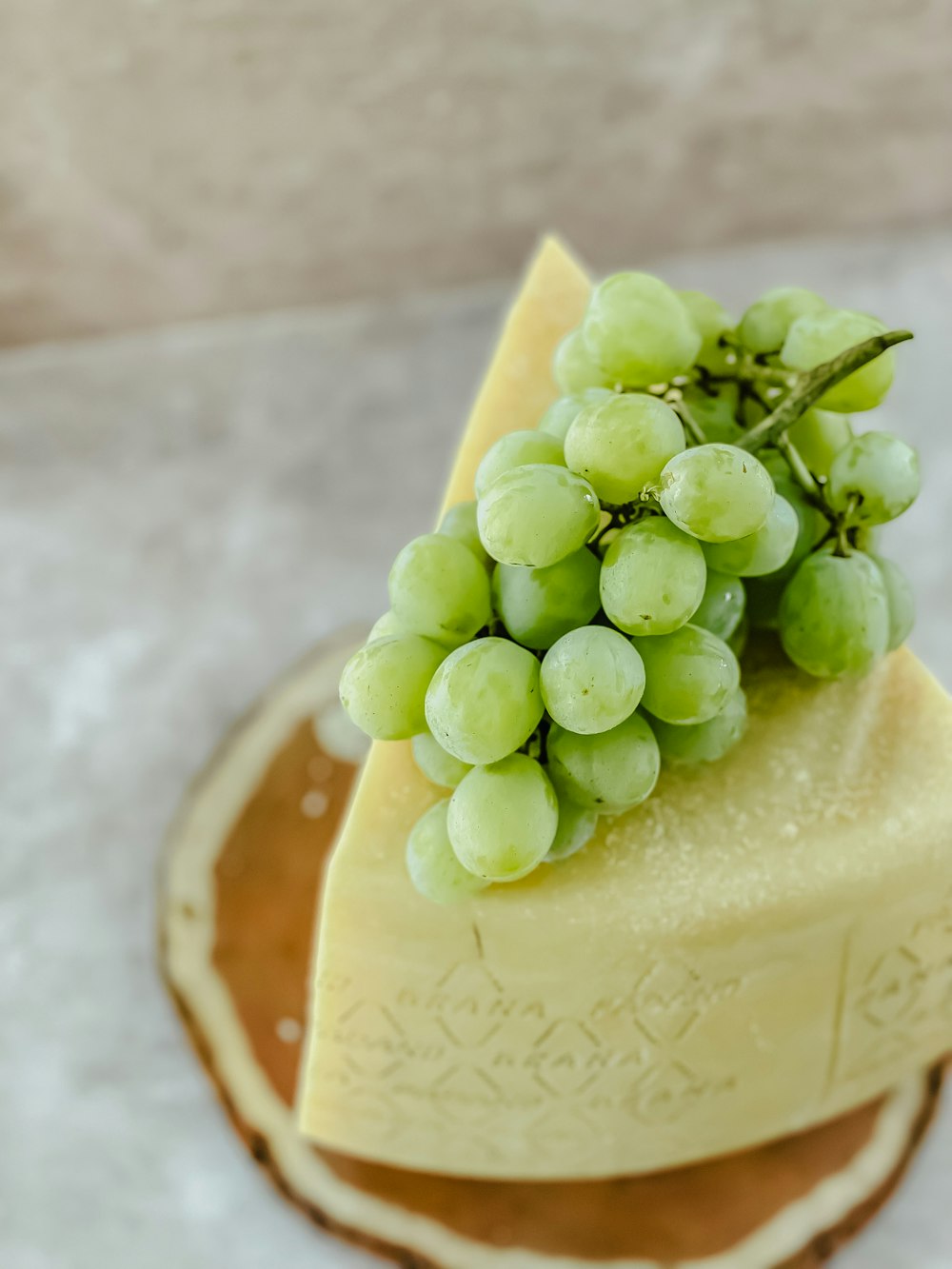 a piece of cheese with grapes on top of it