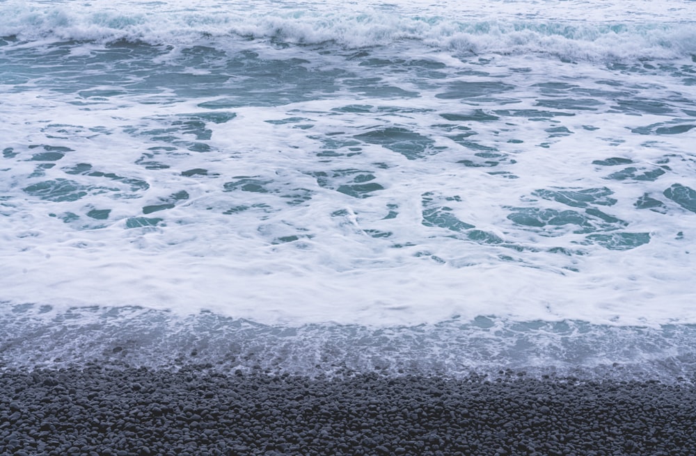 a surfboard sitting on top of a beach next to the ocean