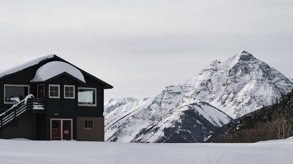 a house in the snow with a mountain in the background