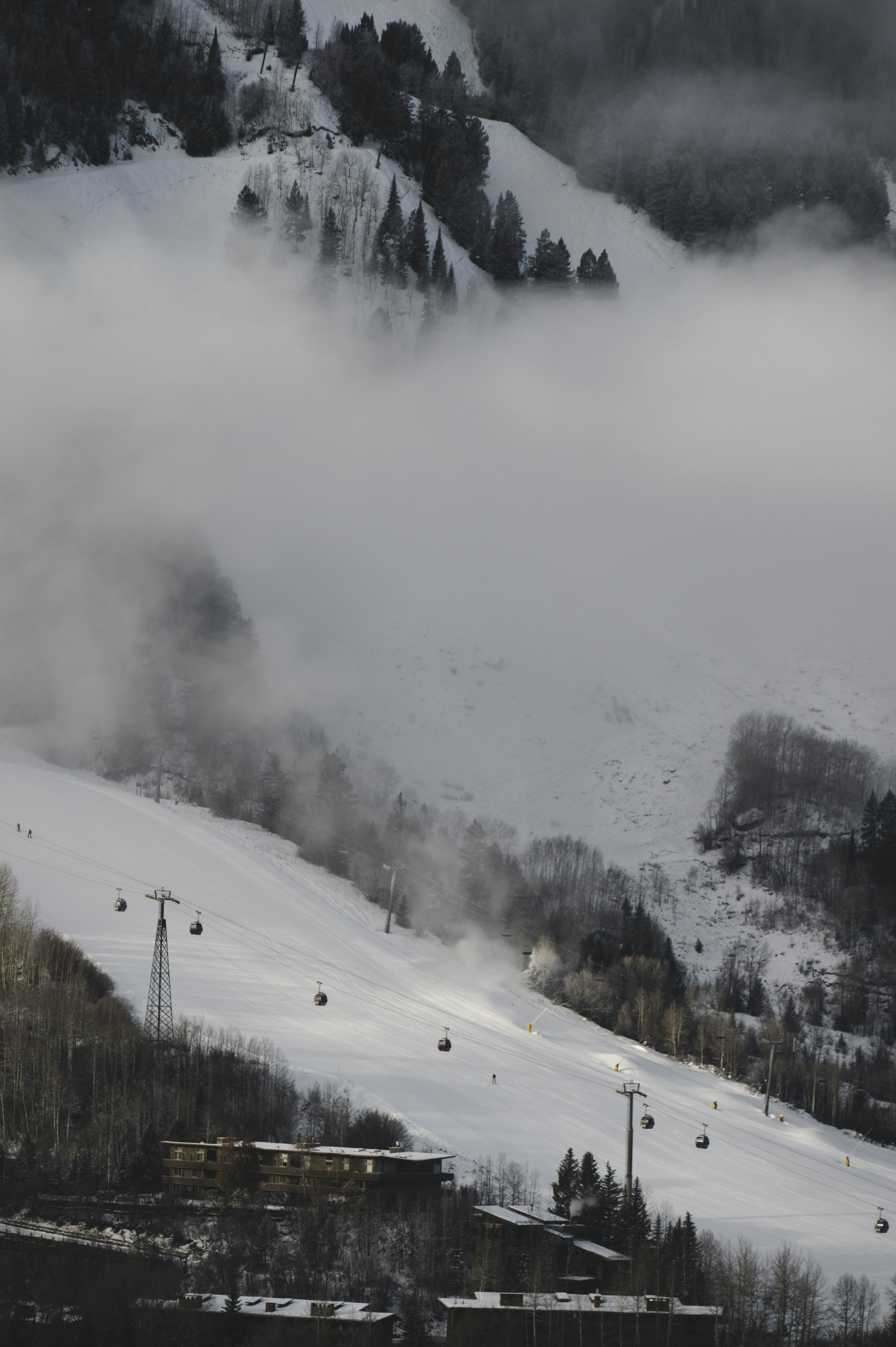 a snow covered mountain with a ski lift in the distance