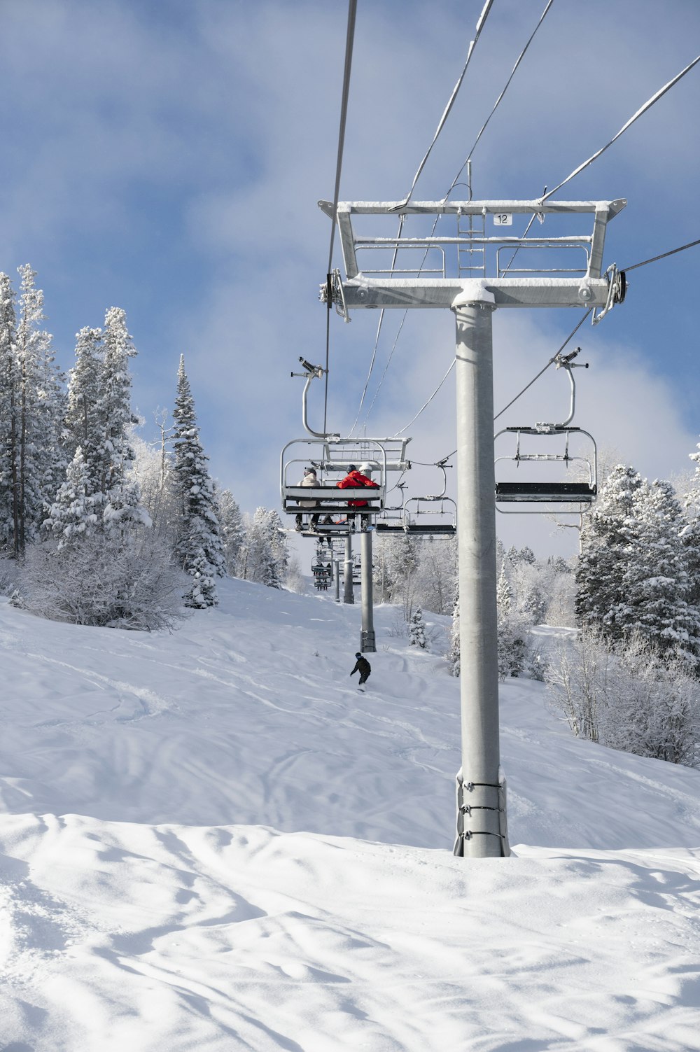 a ski lift going up a snowy mountain