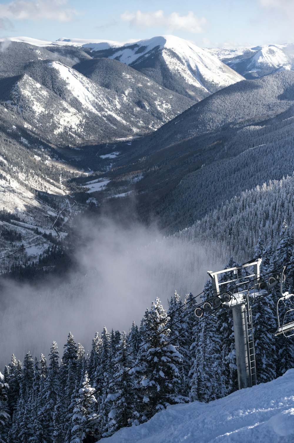 a ski lift going up a snowy mountain