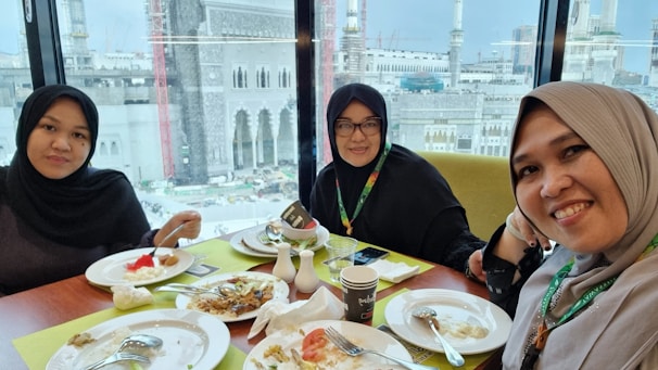 Smiling pilgrims sharing their Umrah experience in a cozy setting