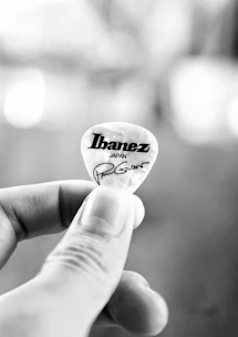 A fan wearing Echoforge wristbands and holding a signed guitar pick.