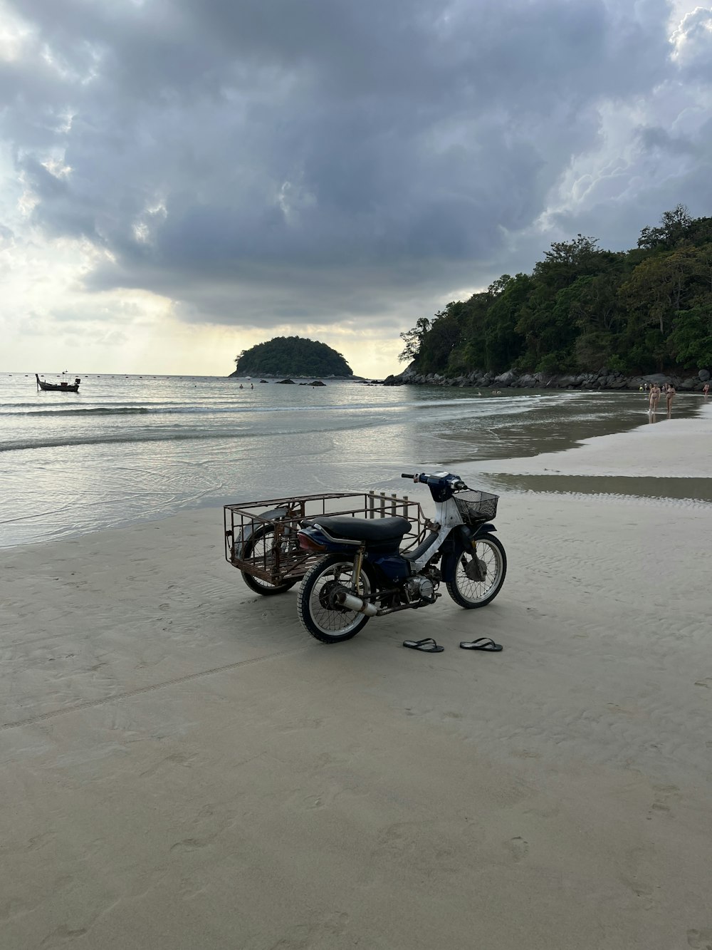 a motorcycle parked on a beach next to the ocean