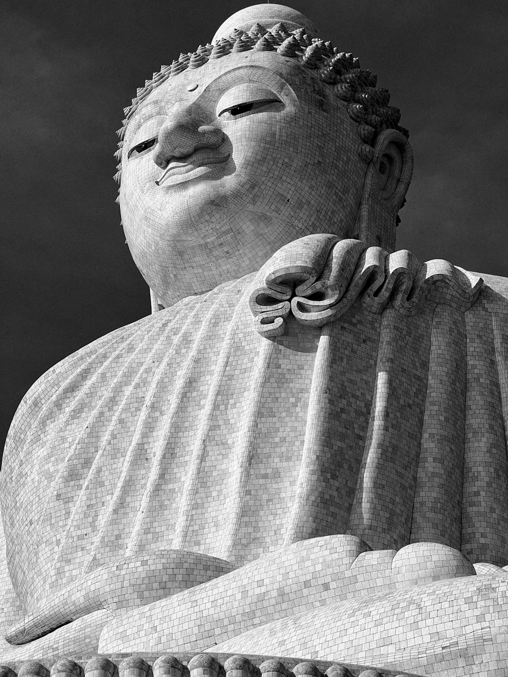 Una foto in bianco e nero di una grande statua di Buddha