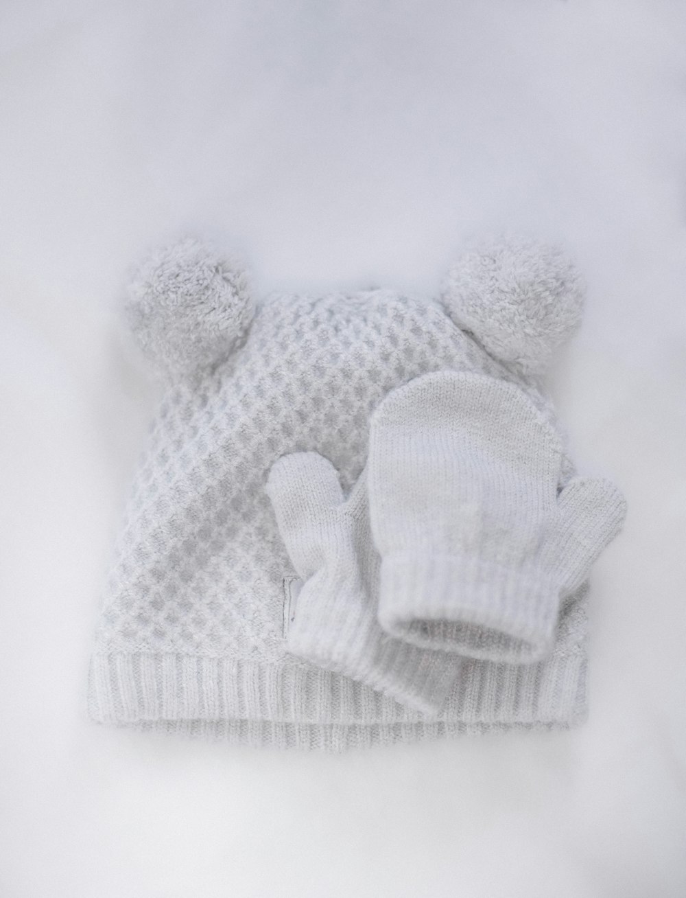 a white knitted hat and mitten on a white background