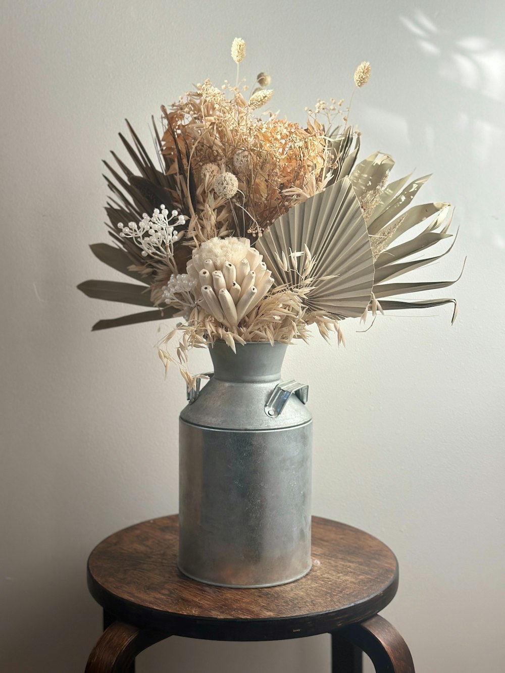 a vase filled with dried flowers on top of a table