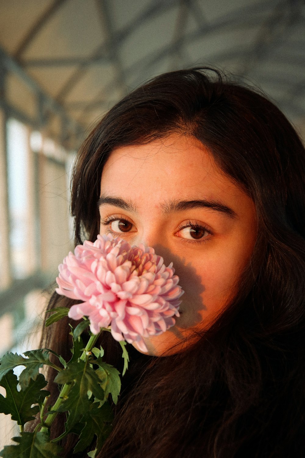 a woman holding a flower in front of her face