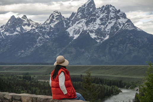 A Great Falls professional reviewing retirement plans with a client, with Montana scenery visible through the window.