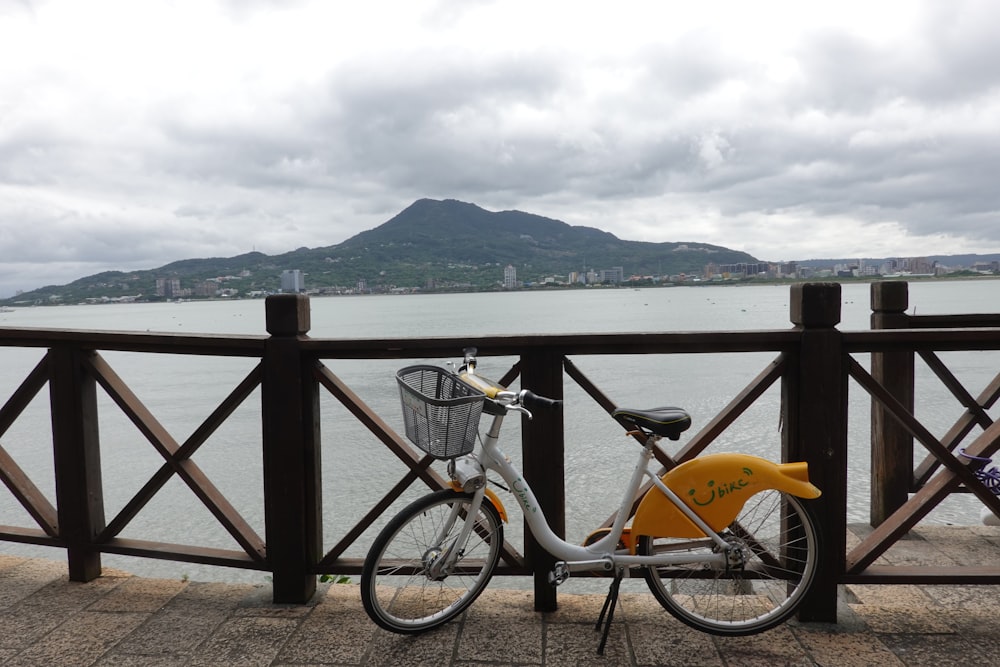 a bicycle parked next to a railing overlooking a body of water