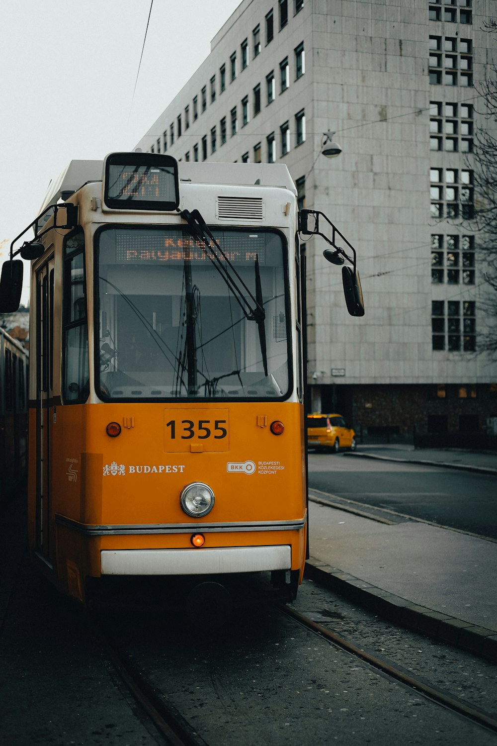 an orange and white bus on a city street