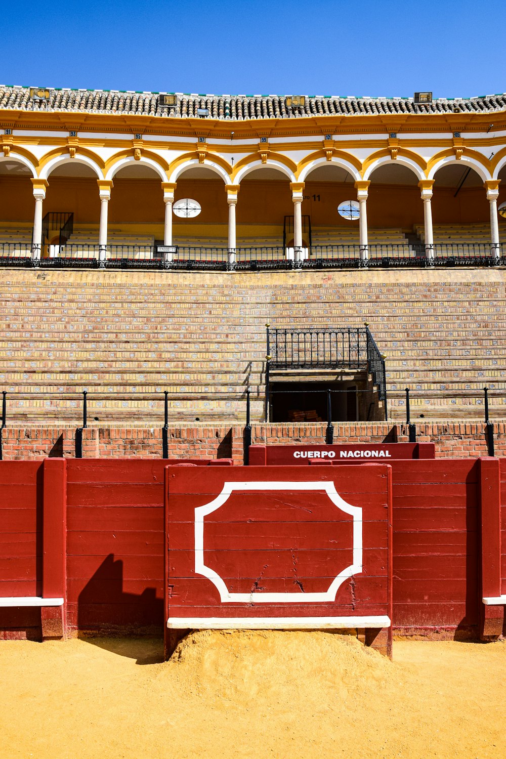 a red fence in front of a brick building