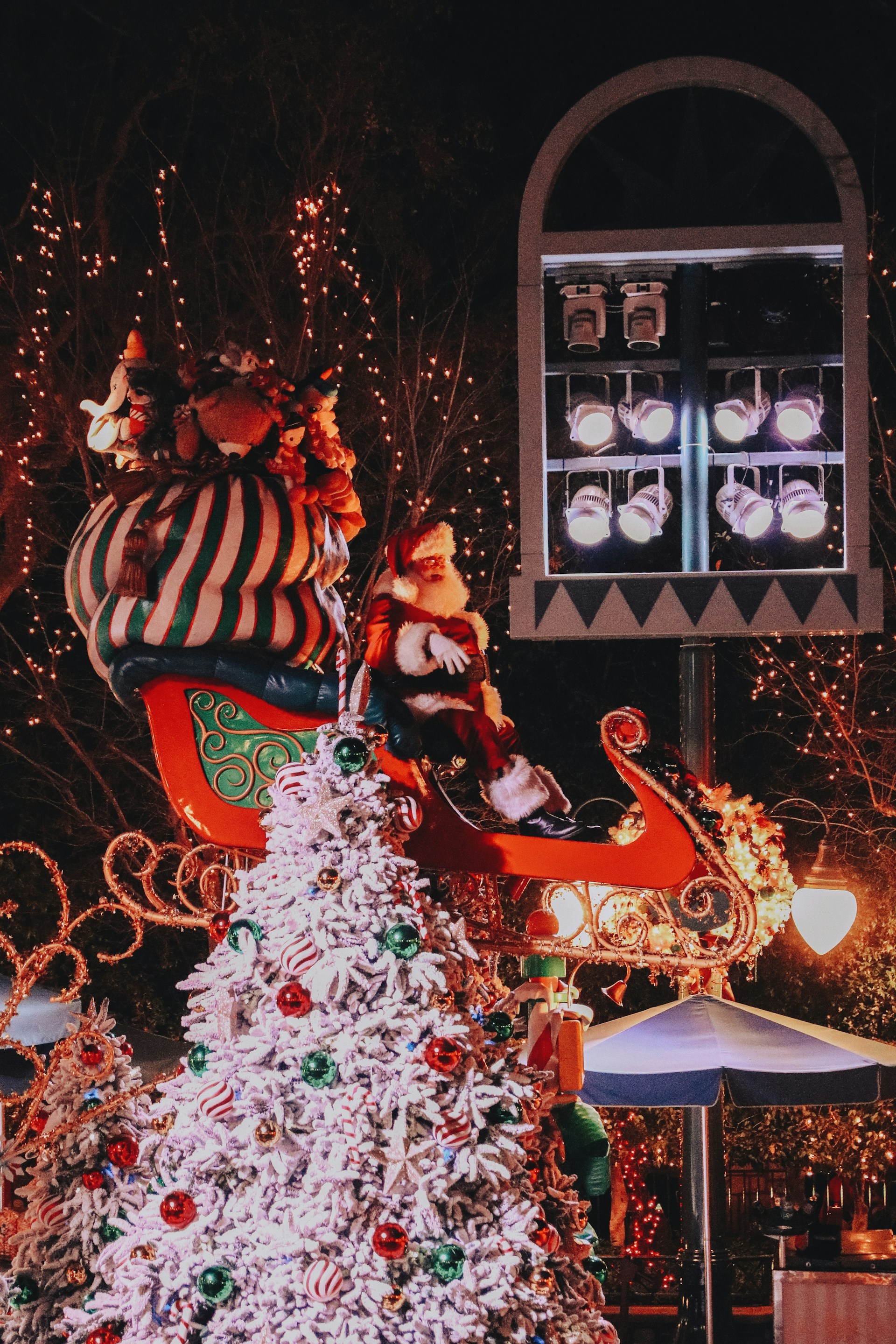 A festive scene of Santa Claus joyfully riding his sleigh through a snowy landscape, with twinkling stars in the night sky.
