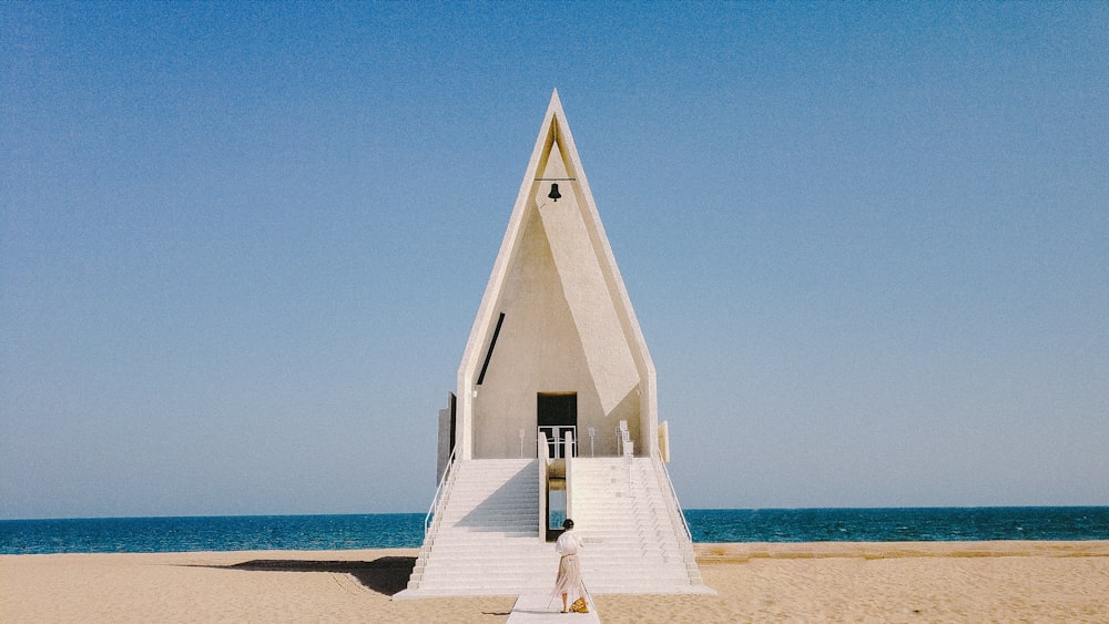 a person walking up a set of stairs on a beach