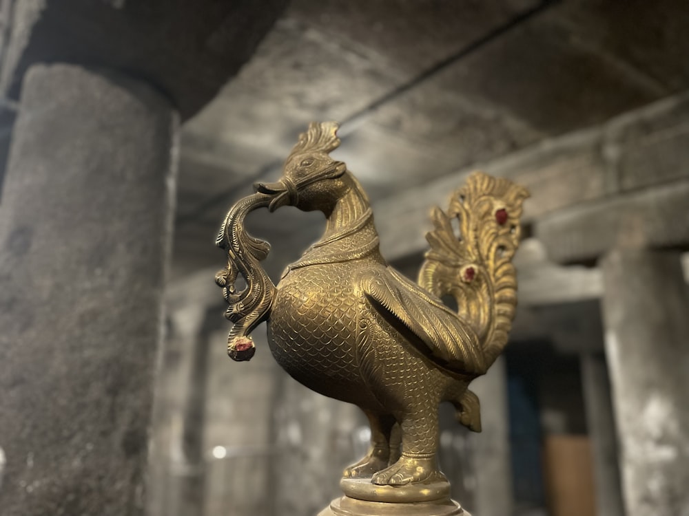 a golden statue of a rooster on a pedestal