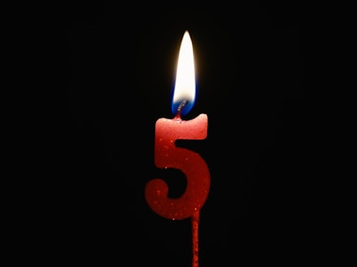 a red candle with a lit candle on top of it