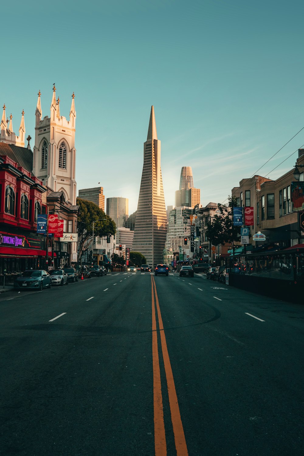 a city street with a steeple in the background