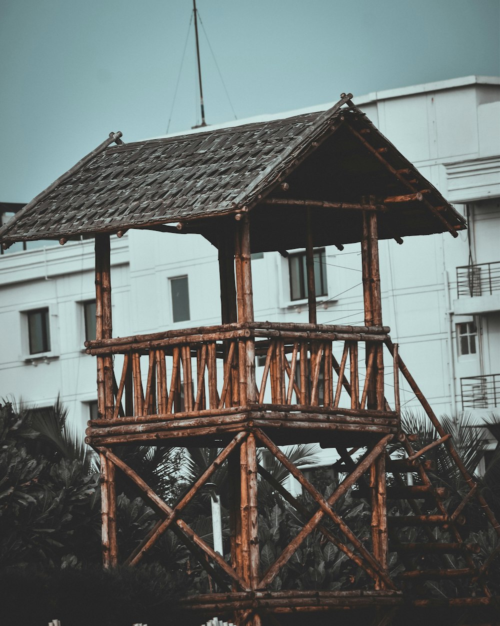 a wooden structure with a roof made of bamboo