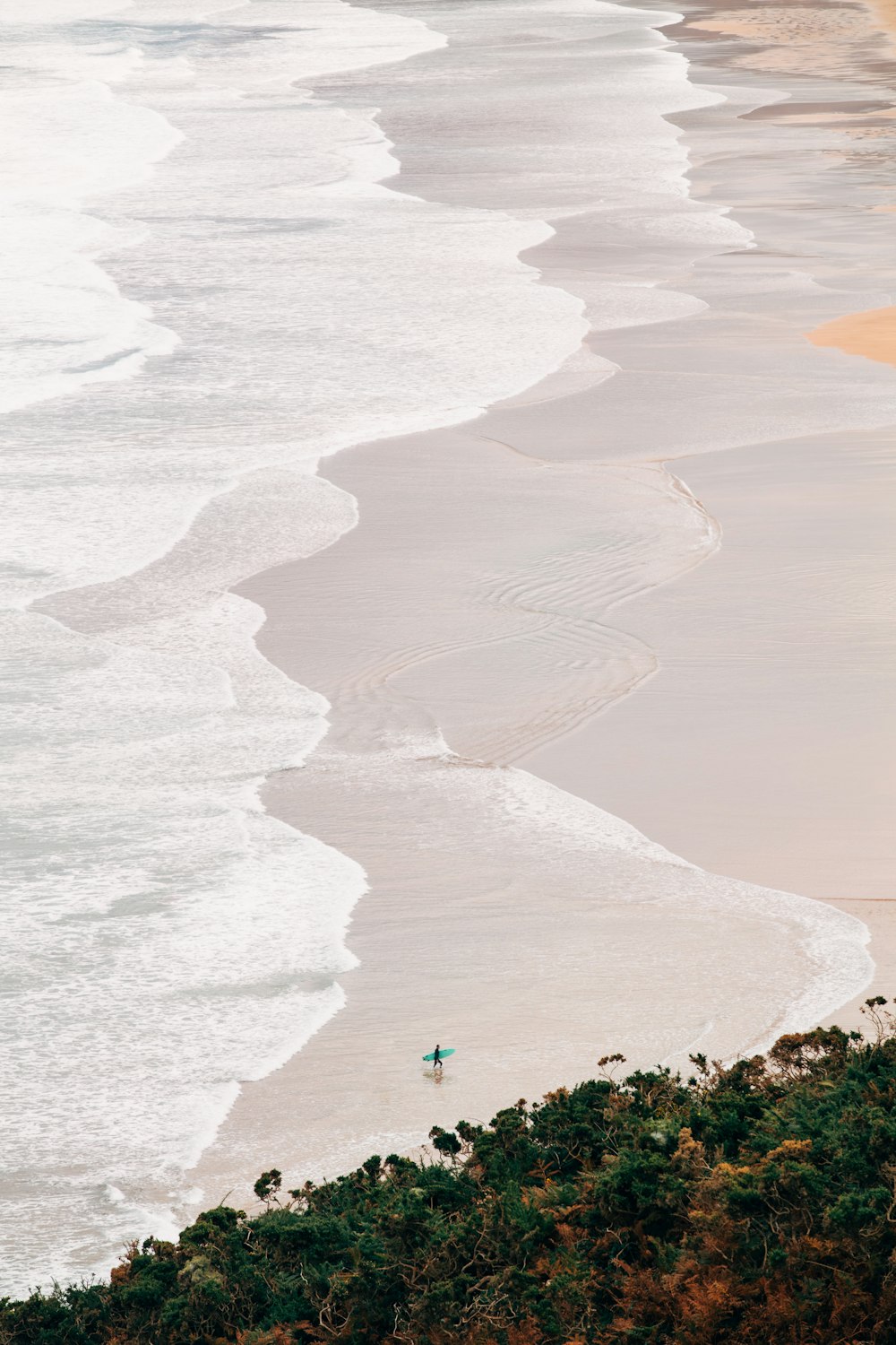 a person on a surfboard in the water near the beach