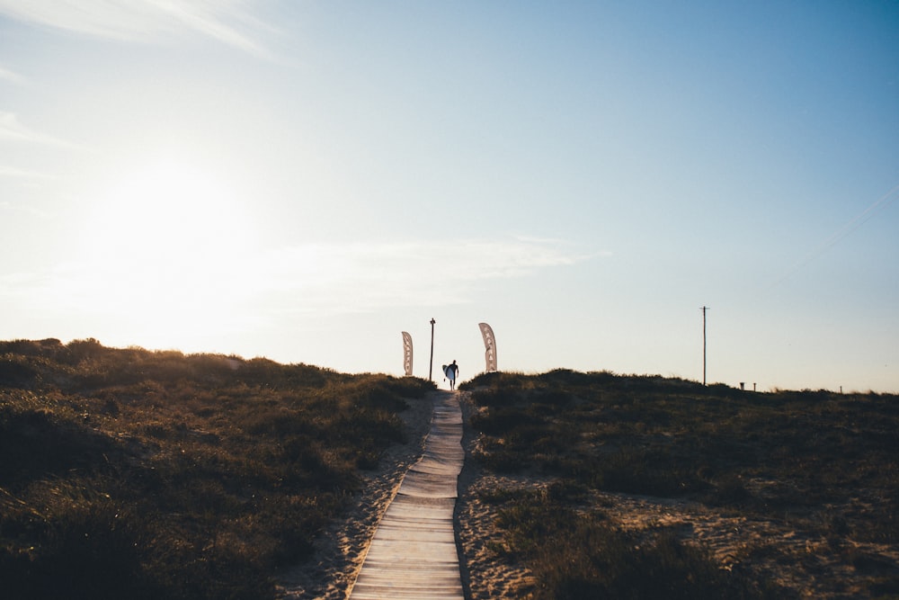 a person standing on top of a hill flying a kite