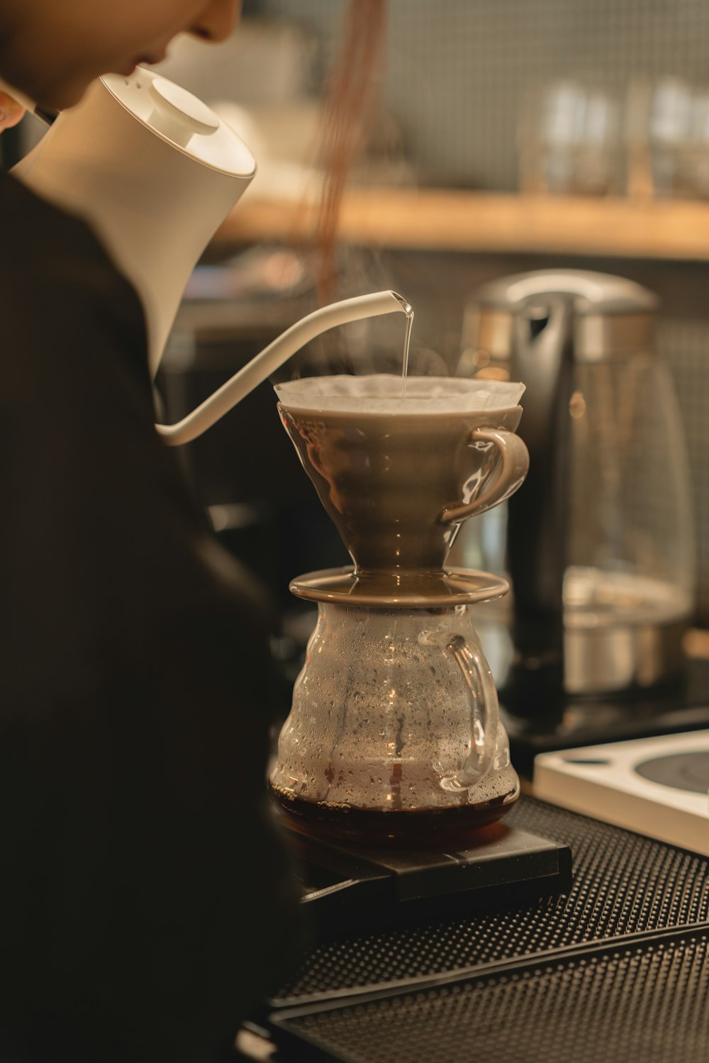 a person pours coffee into a coffee pot