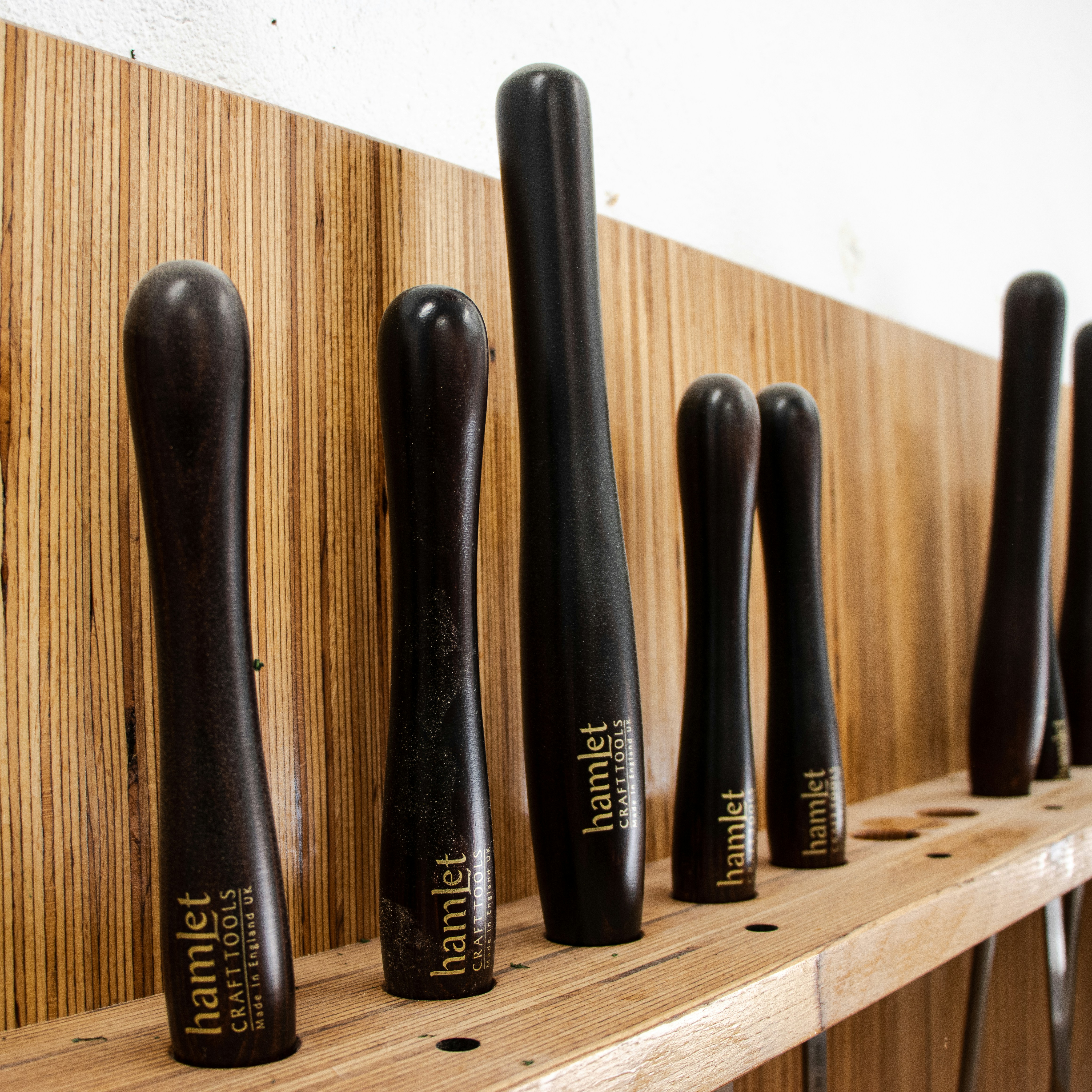 a row of black toothbrushes on a wooden shelf