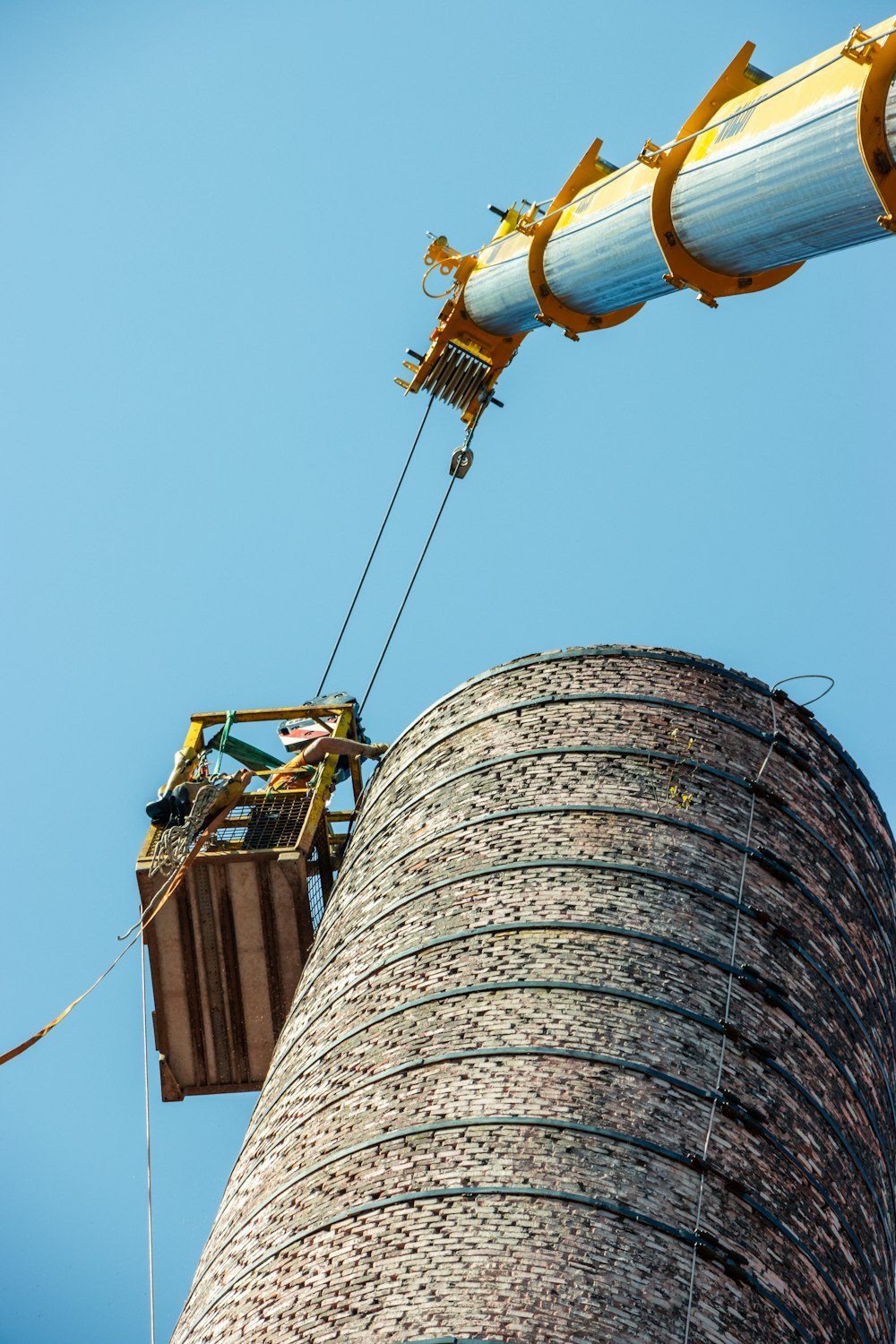 a man on a crane working on a tower