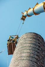 a man on a crane working on a tower