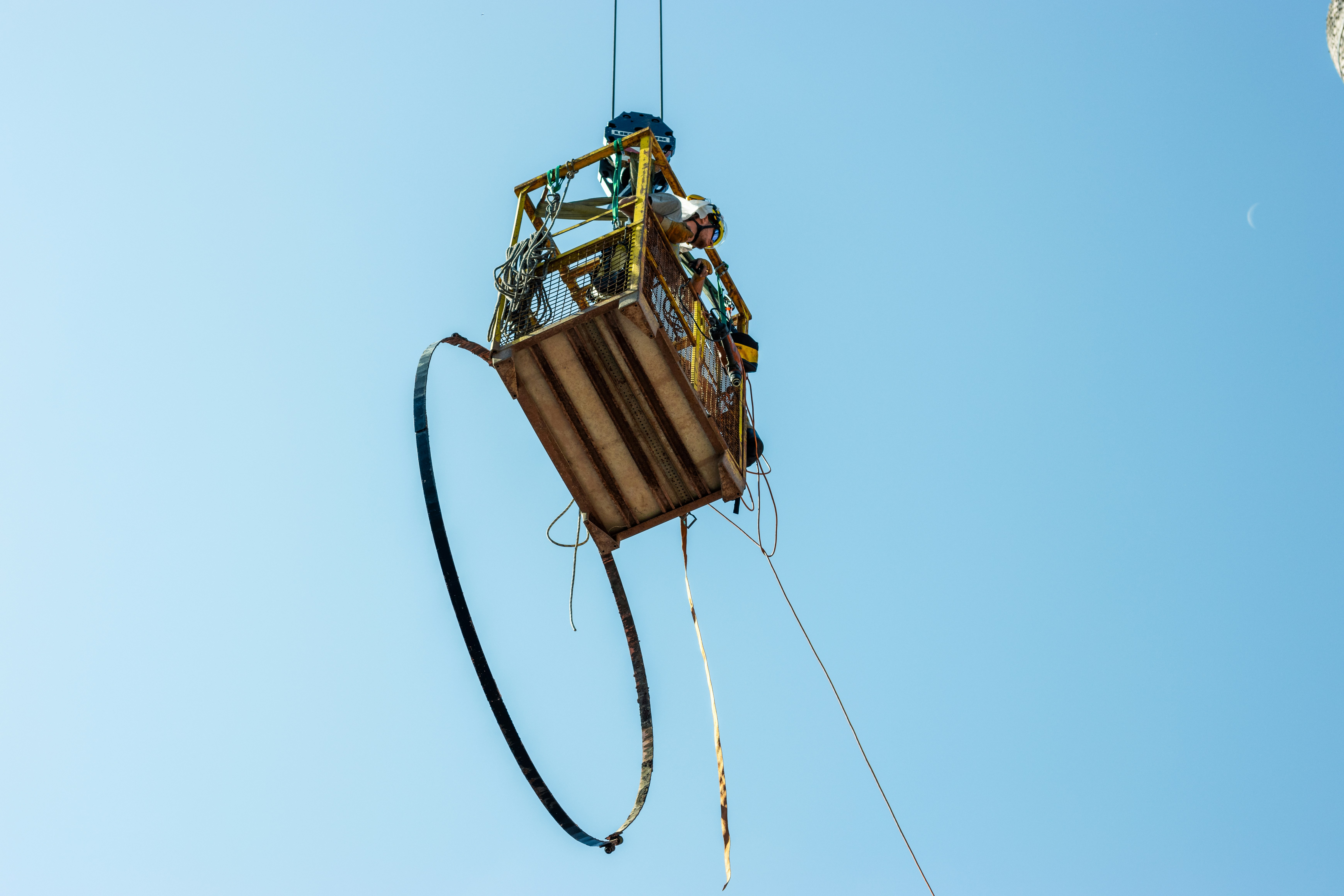 a crane is lifting a bucket on a wire