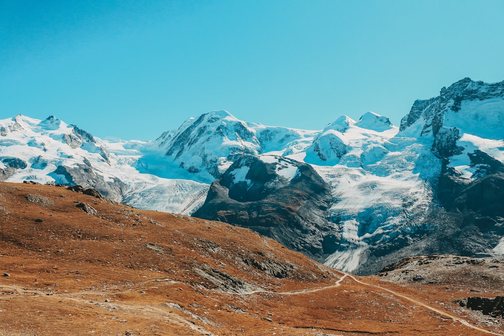 a mountain range with snow covered mountains in the background