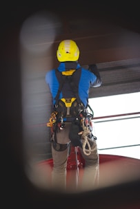 a man wearing a yellow helmet and safety gear