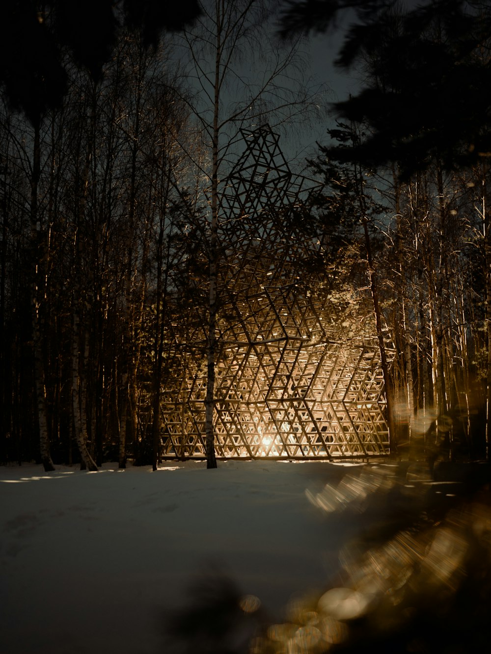 a wooden structure in the middle of a forest at night