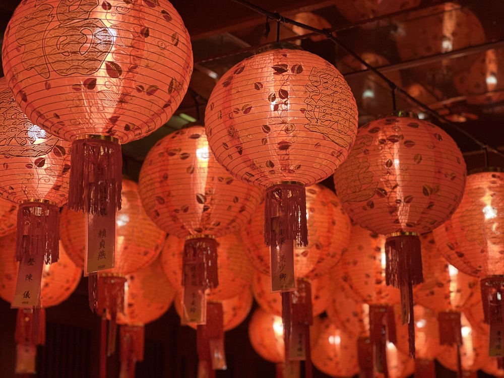 a room filled with lots of orange paper lanterns