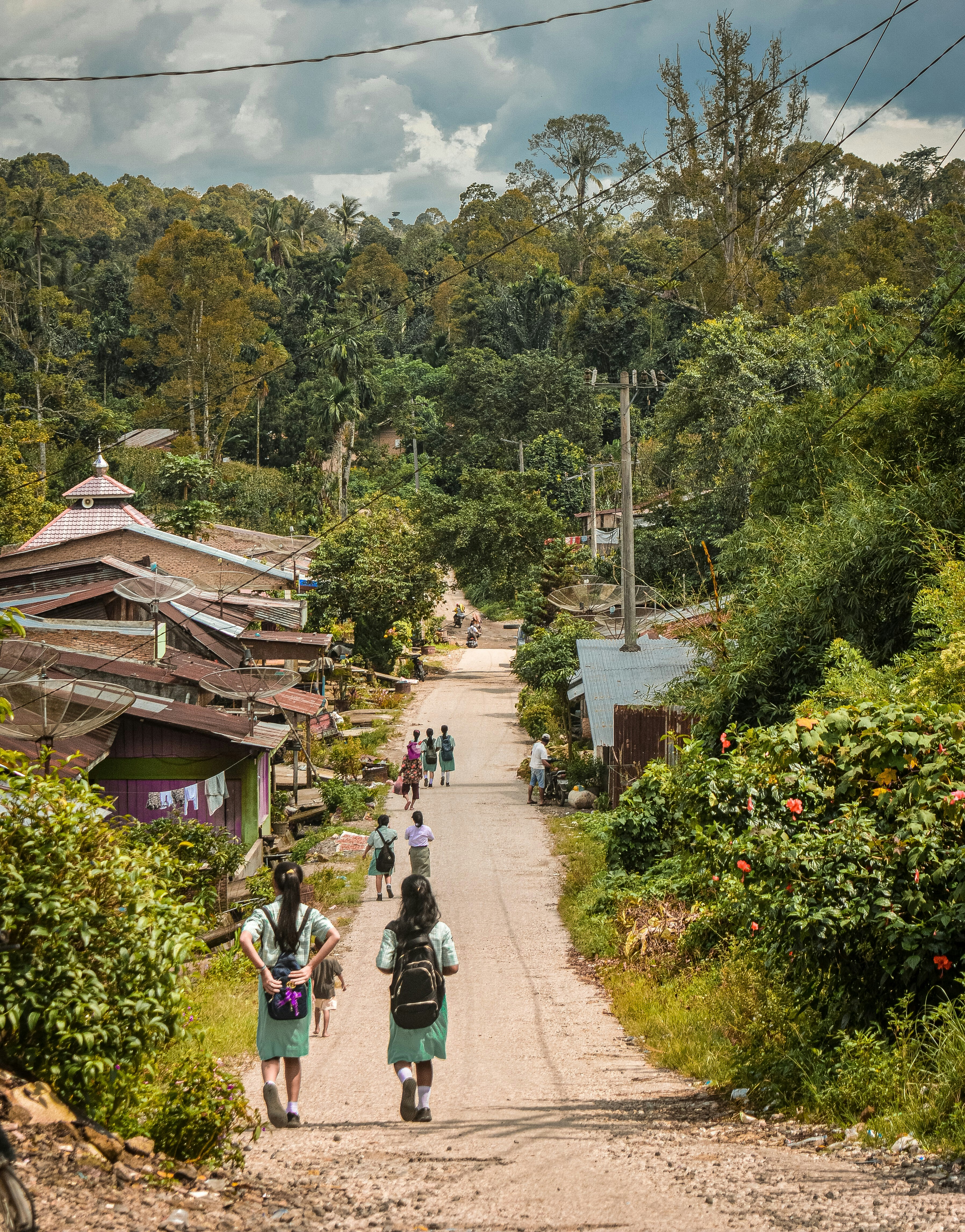 um grupo de pessoas andando por uma estrada de terra