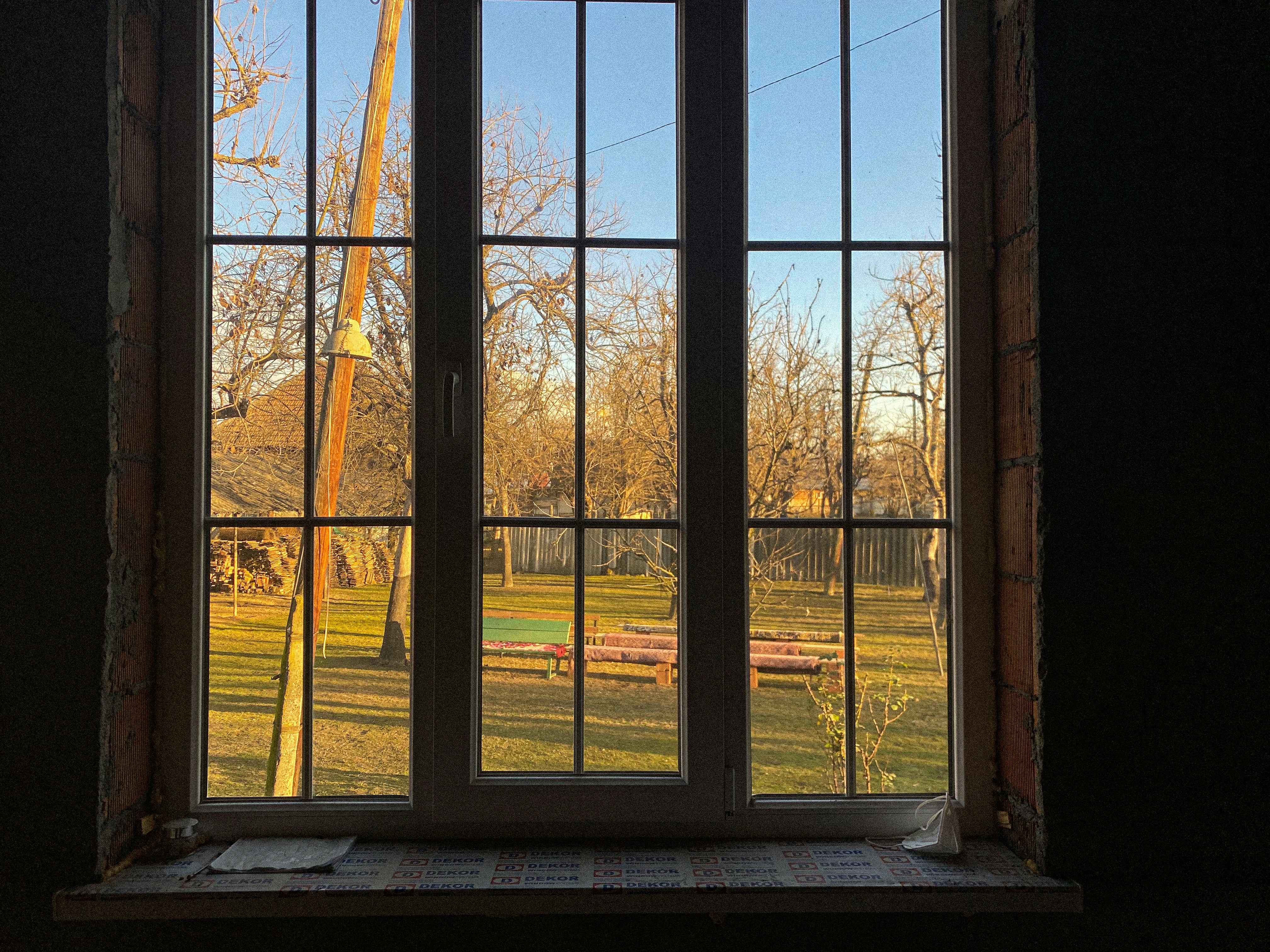a window with a view of a field and a crane