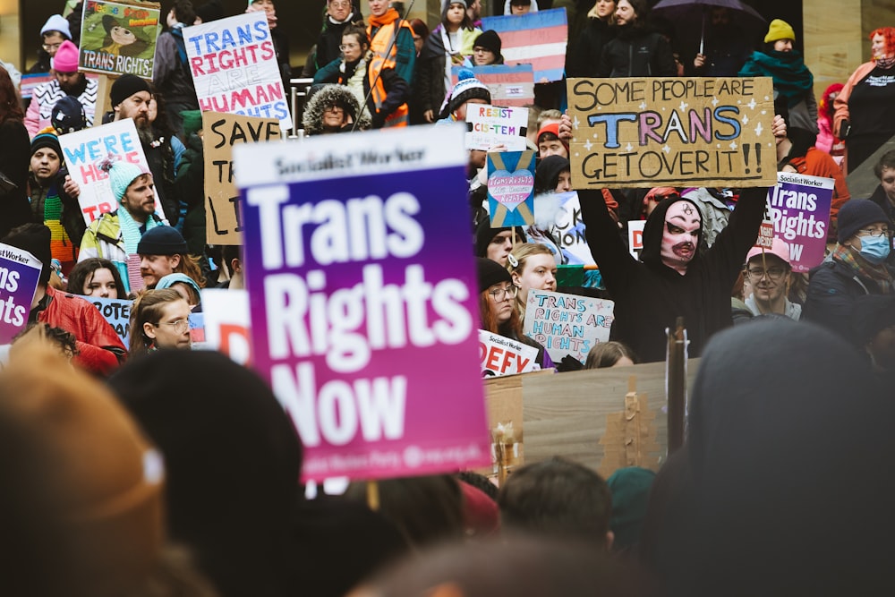 a crowd of people holding signs in the air