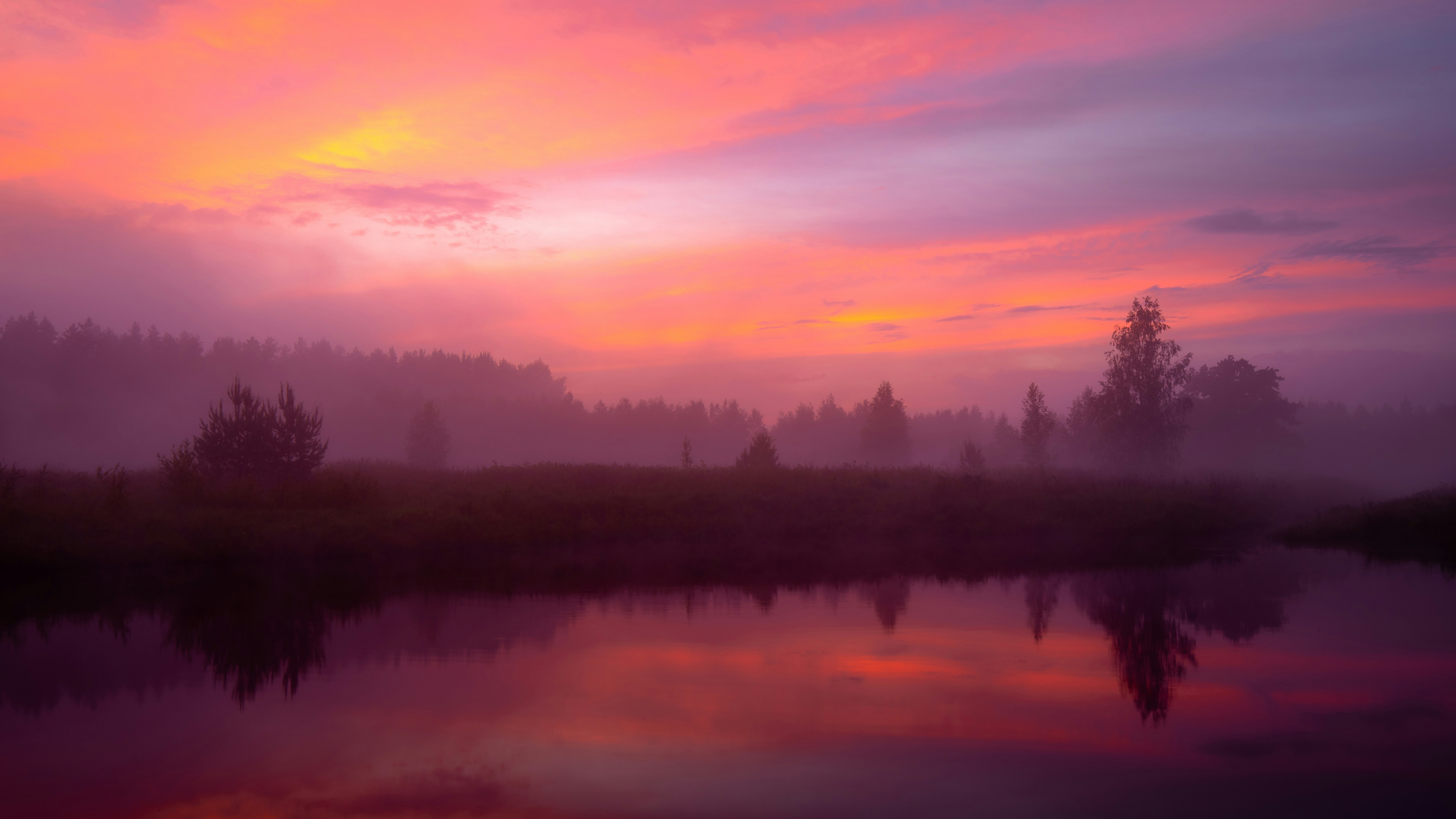 A beautiful sunset over a lake with trees in the background photo ...