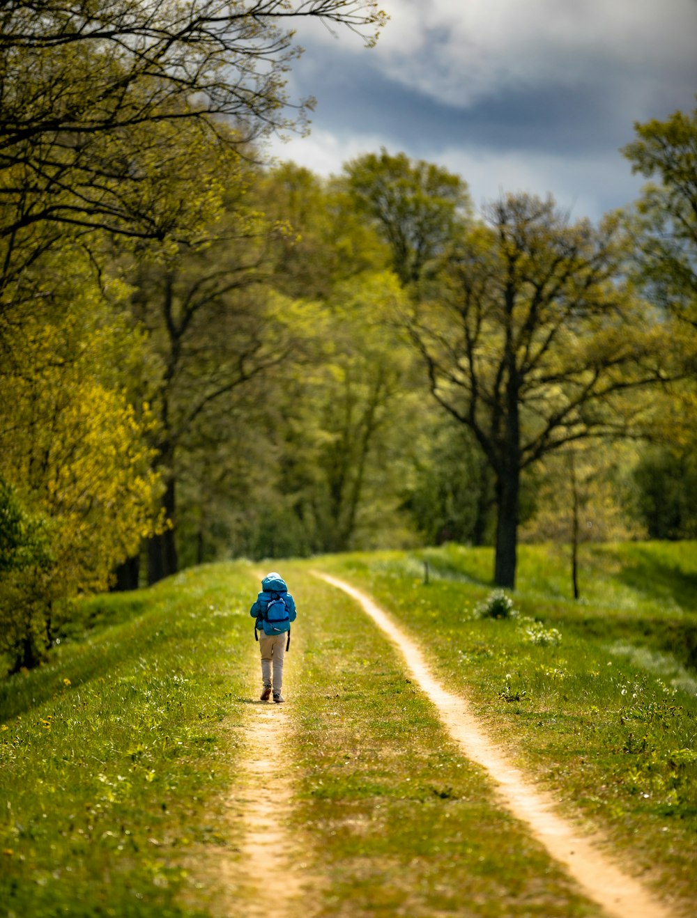 a little boy walking down a dirt road