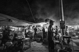 A candid moment of laughter between friends sharing street food in a lively night market