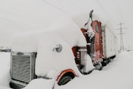 Powerful tow truck pulling a large vehicle through snowy conditions with electric blue accents.