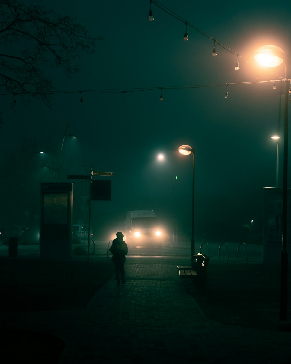 a man walking down a sidewalk at night