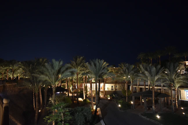 A stunning nighttime view of the villa illuminated with soft, warm lights.