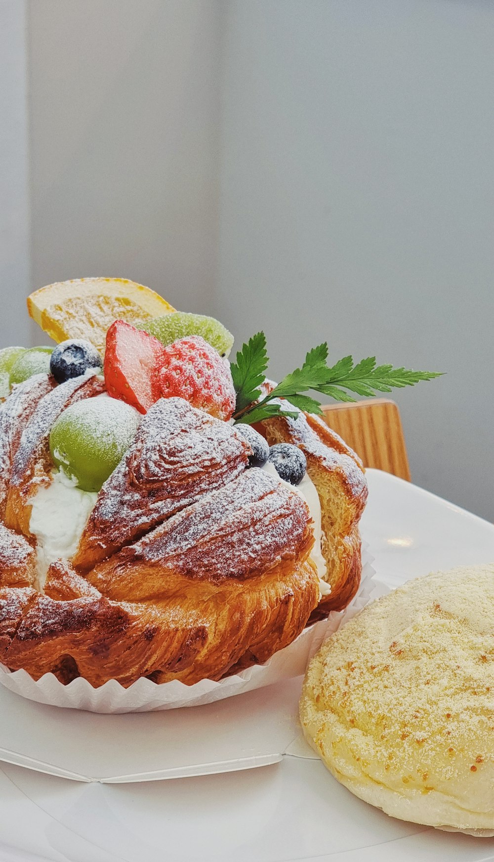 a white plate topped with a pastry covered in powdered sugar