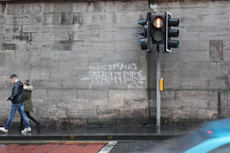a man walking down a street next to a traffic light
