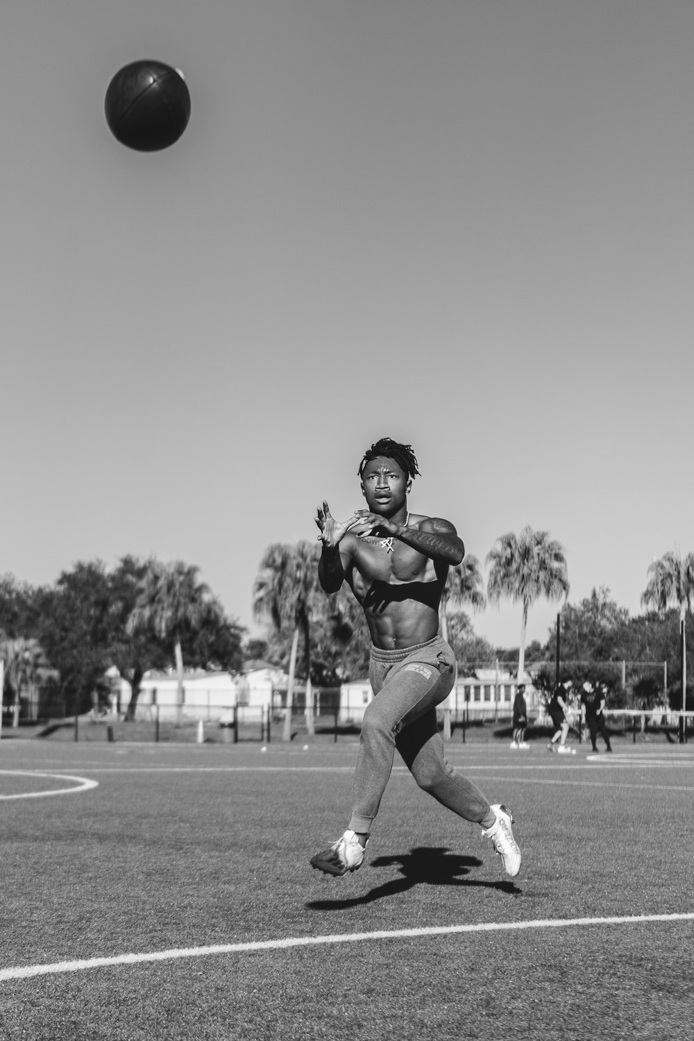 a black and white photo of a man throwing a ball