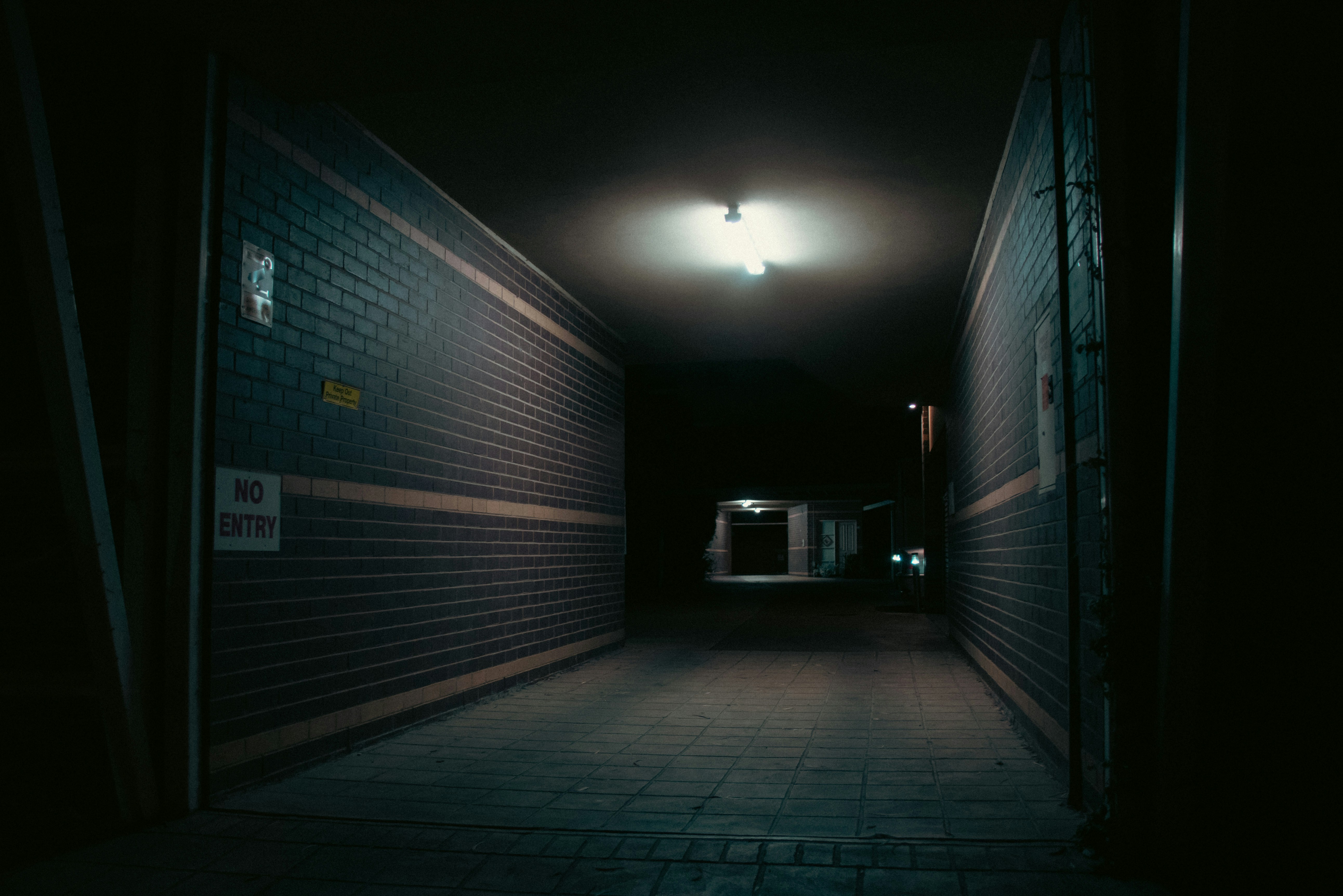 a dimly lit hallway with a brick wall