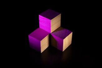 Close-up of GeerBlock pieces glowing softly against a smoky black background.