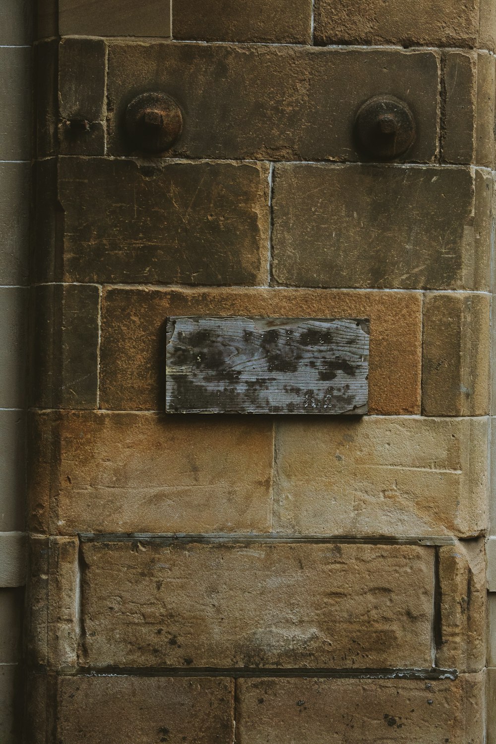 a close up of a brick wall with a sign on it